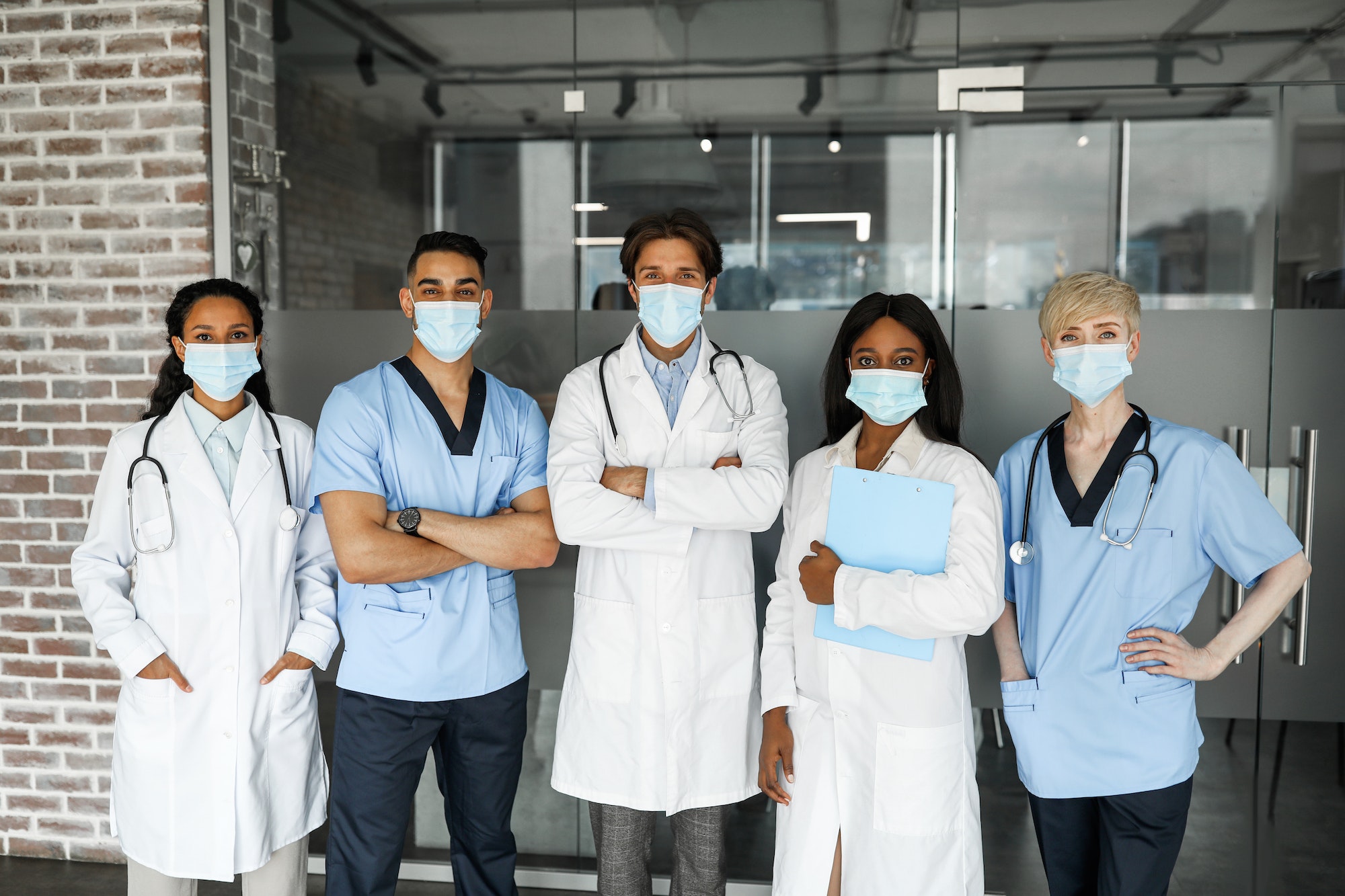 International medical team in face masks having team-building